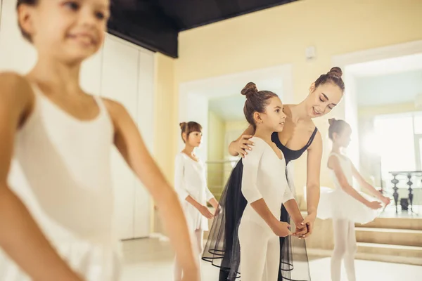 Young professional female ballerina teaching girls to dance — Stock Photo, Image