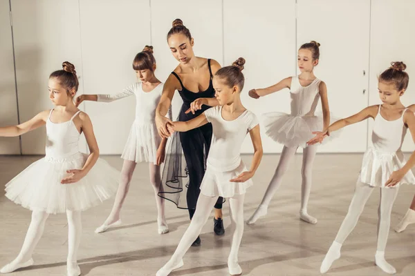 Giovane donna caucasica insegnare giovani ragazze a ballare balletto classico — Foto Stock