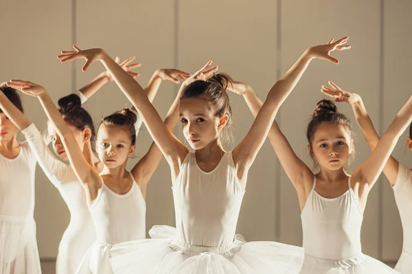 Groupe de petites ballerines caucasiennes se tiennent en rangée et pratiquent le ballet — Photo