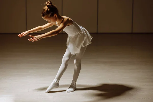 Cute caucasian little ballerina in white ballet costume and pointe shoes dancing in studio — 스톡 사진