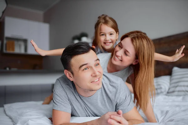 Vriendelijke Kaukasische familie op bed — Stockfoto