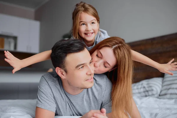 Retrato de hermosa familia sonriente en la cama — Foto de Stock