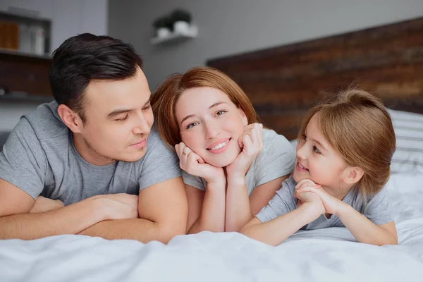 Retrato de la familia joven en la cama — Foto de Stock