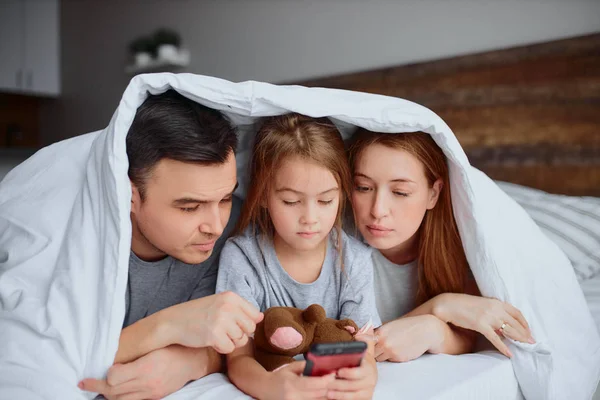 Jong Kaukasisch familie bestond uit vader mam en dochter op bed — Stockfoto