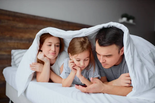 Jong Kaukasisch familie bestond uit vader mam en dochter op bed — Stockfoto