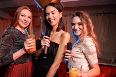 Karaoke barda gülümseyen üç kız