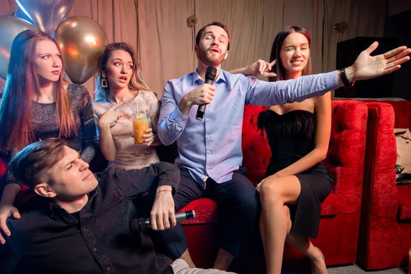 Skupina radostných přátel zpívajících v karaoke baru — Stock fotografie