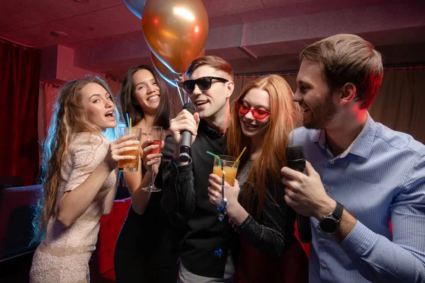 Beautiful girls and handsome guys singing in mic at party — Stock Photo, Image