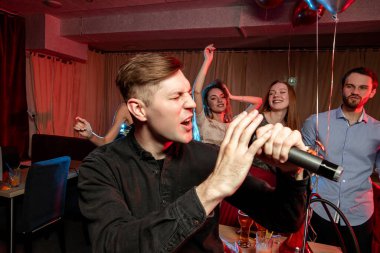 Karaoke yapan adama yan bakış, şarkı söylemek.