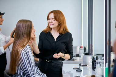 Güzellik salonunda müşterisi olan bir makyöz.