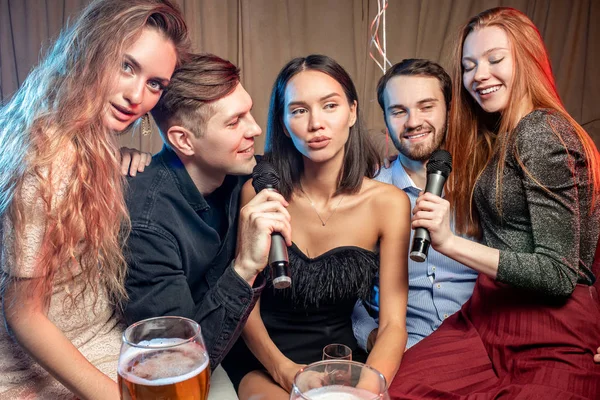 Young caucasian clubbers in karaoke bar — Stock Photo, Image