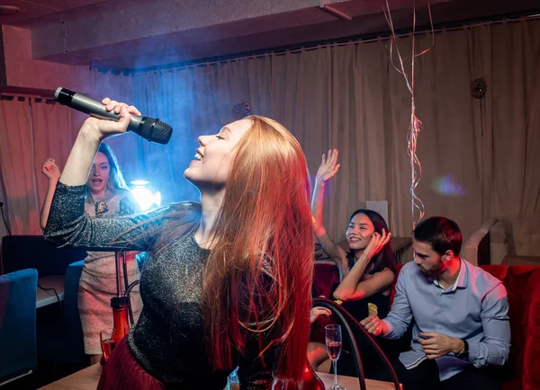 Emocionální zpěvačka v karaoke baru — Stock fotografie