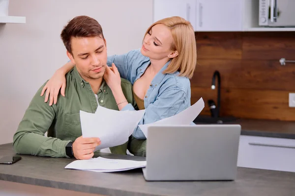 Прекрасная позитивная пара проверяет свои финансы на дому — стоковое фото