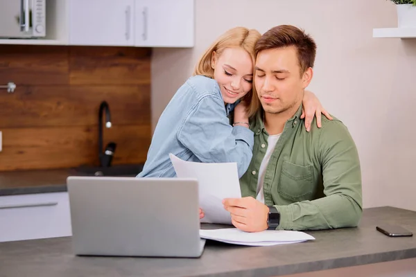Gelukkig stel thuis met moderne laptop, familie overweegt hypotheek of verzekering — Stockfoto