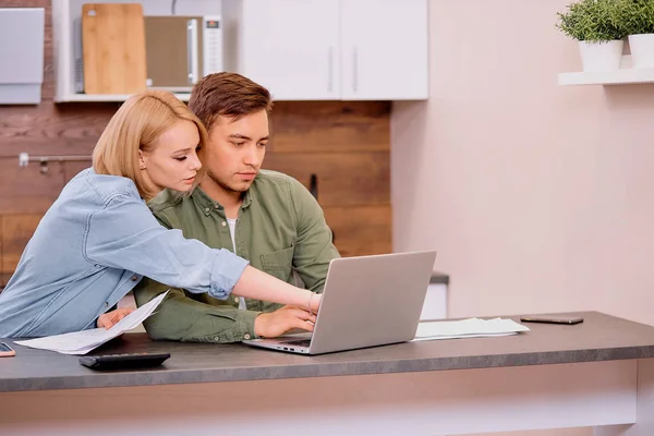 Jong gelukkig paar zitten met documenten bespreken over contant geld rekeningen in de huiskeuken — Stockfoto