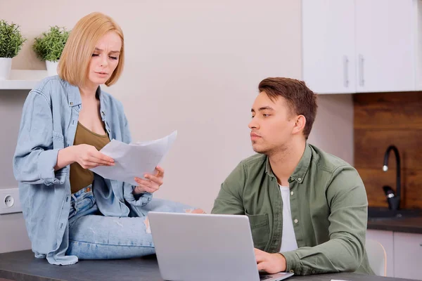 Kaukasische jonge echtgenoten met laptop en documenten thuis — Stockfoto