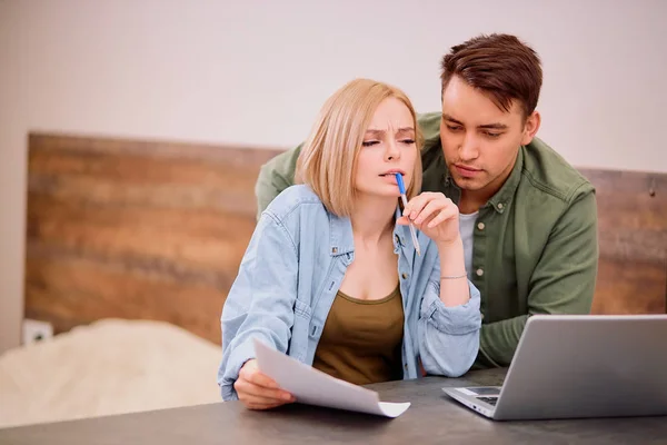 Раздраженная и грустная супружеская пара, анализирующая с помощью ноутбука — стоковое фото