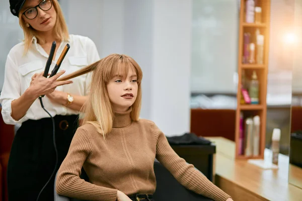 Profesjonalny fryzjer zrobić fryzurę do młodej białej dziewczyny — Zdjęcie stockowe