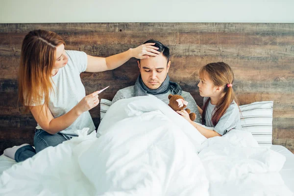 Concepto de familia, salud y personas. familia enferma en la cama en casa — Foto de Stock