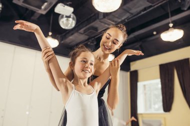 friendly smiling ballet dancer and little girl
