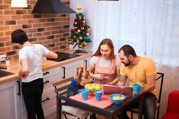 Pais jovens e crianças têm refeição na cozinha — Fotografia de Stock