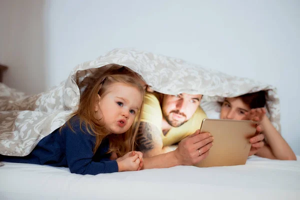 Familia amigable emocional disfrutar viendo película en la cama —  Fotos de Stock