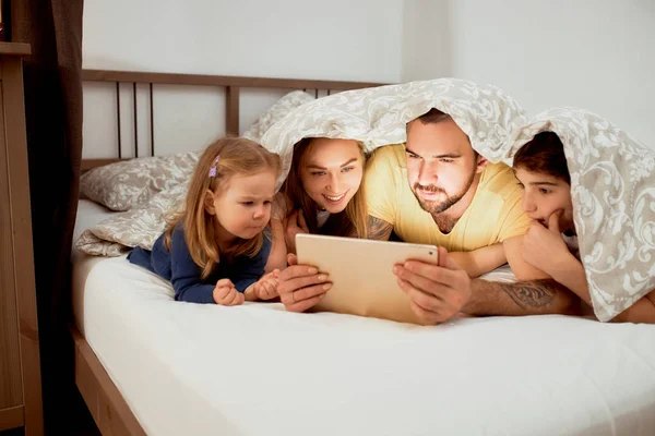 Mooie familie op bed, breng de ochtend samen door — Stockfoto