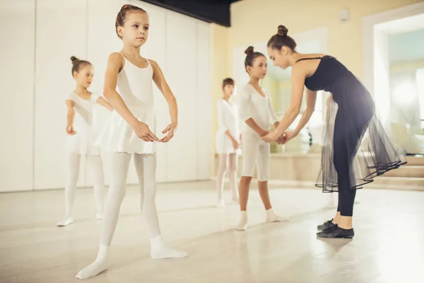 Jovem bailarina profissional praticando e ensinando crianças — Fotografia de Stock