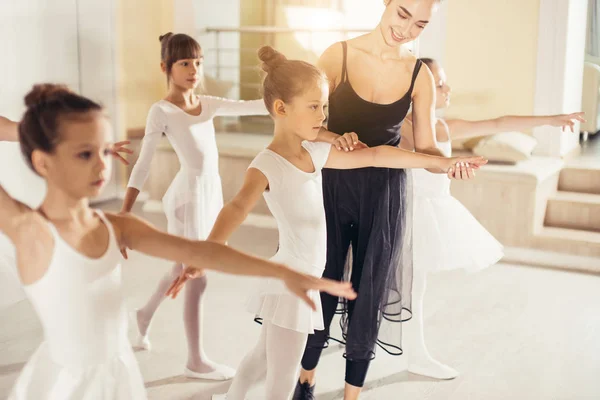 Ung tränare tränare för balettskolan hjälper unga ballerinor — Stockfoto