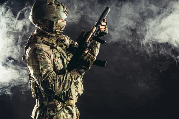 Soldat homme tirant à travers la fumée brumeuse — Photo