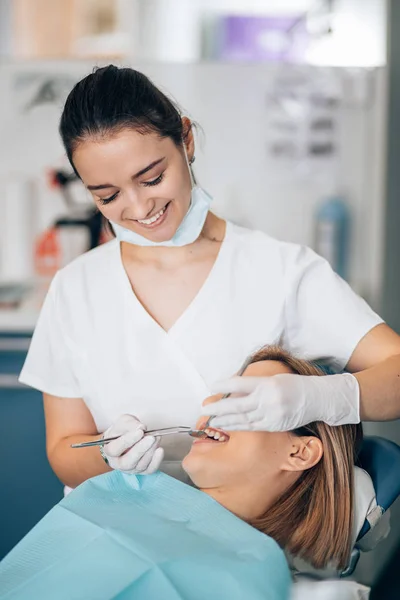 Beautiful young dentist treating teeth — Stockfoto