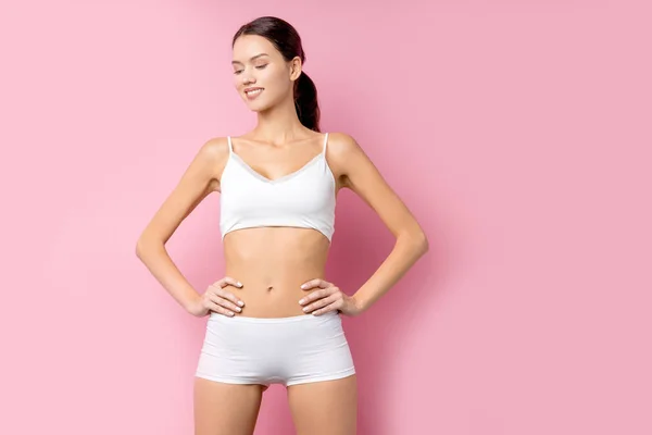 Szczęśliwa młoda kobieta z pięknym szczupłym ciałem w białych ubraniach sportowych - izolowane na różowym tle — Zdjęcie stockowe