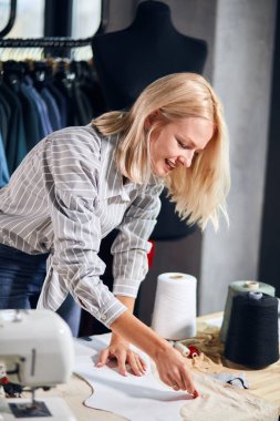 Gülümseyen güzel moda tasarımcısı stüdyoda çalışıyor.