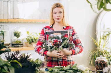 Genç ve güzel çiçekçi kendi dükkanında