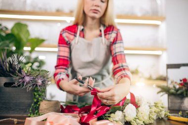 Çiçeklerden kompozisyon yapan güzel bir bayan çiçekçi.
