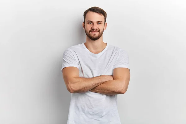 Sorridente bell'uomo in elegante T-shirt in piedi con braccia incrociate — Foto Stock