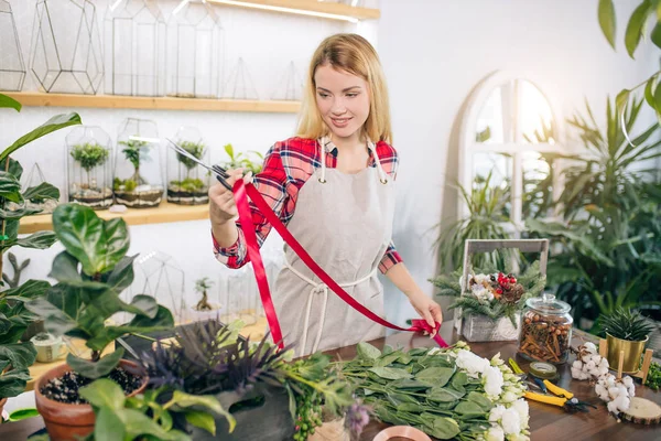 Ung kvinnlig florist med rött band för blommor — Stockfoto