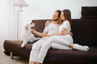 man and woman with dog at home