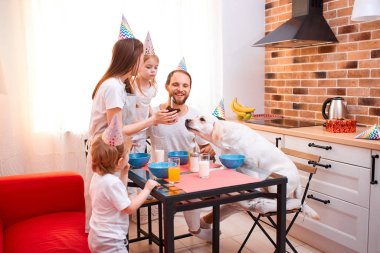 happy domestic dog with owners in kitchen