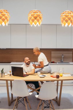 Happy couple discussing new project on laptop and smiling