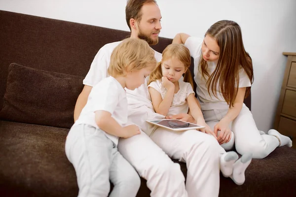 Kinderen en jonge blanke ouders met moderne tablet gadget — Stockfoto