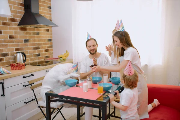 Friendly cheerful family sit celebrating birthday at home with dog — Stok fotoğraf