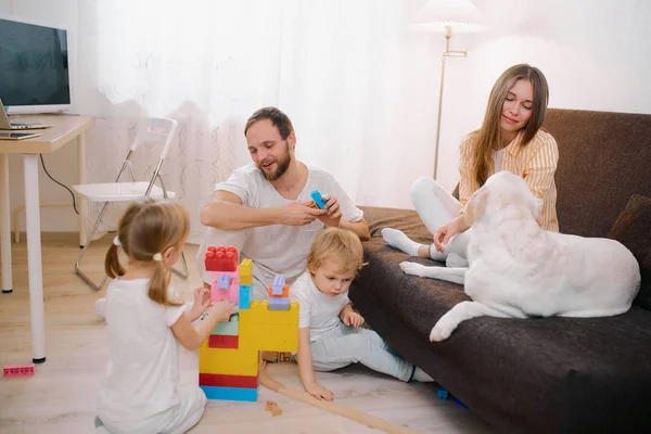 Προσεκτικός άντρας με παιδιά και ελκυστική γυναίκα με σκύλο στο σπίτι — Φωτογραφία Αρχείου