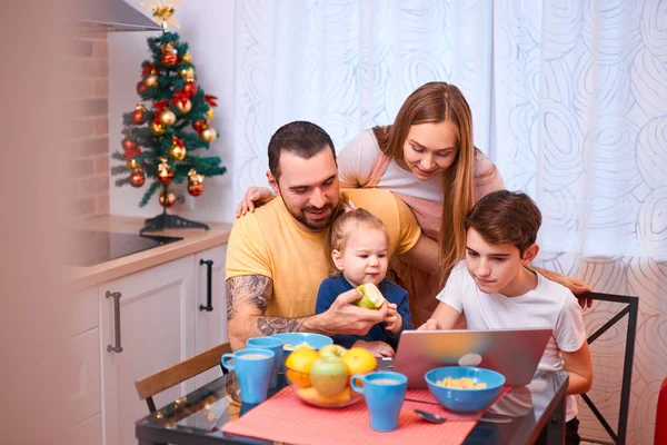 Família caucasiana assistindo filme ou vídeo enquanto toma café da manhã — Fotografia de Stock