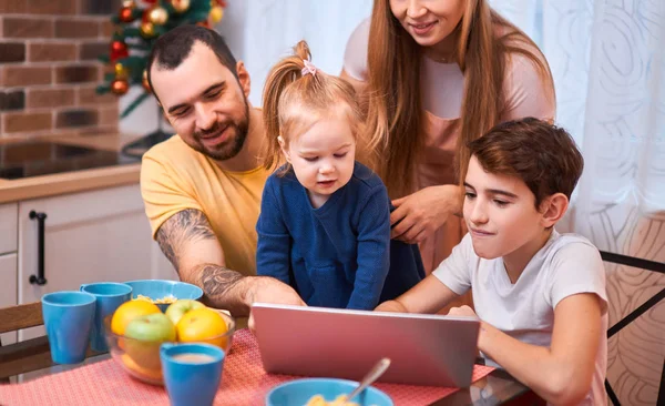 caucasian family watching film or video while having breakfast