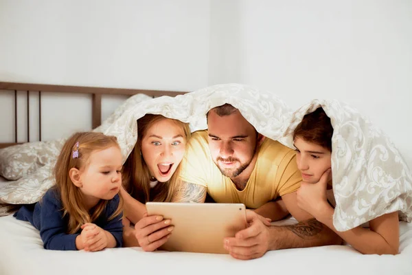 Família amigável emocional gosta de assistir filme na cama — Fotografia de Stock