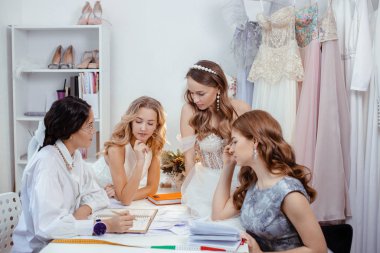 Düğün, alışveriş konsepti. Müşteriler ve terzi tasarımcısı