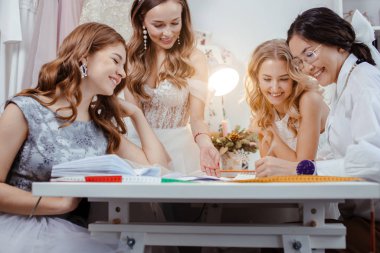 cheerful group of models with professional designer of dresses