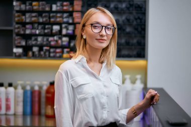 Genç ve güzel beyaz kadın satıcı ya da güzellik salonunda danışman.