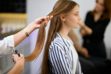 closeup of young girls hair and hairdresser hands